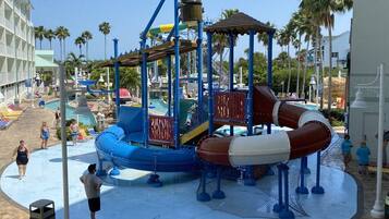 A water park play structure with slides and a pool area.