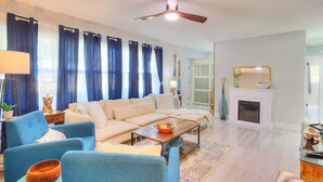 Una sala de estar con sofá, sillones, una mesa de centro y chimenea.