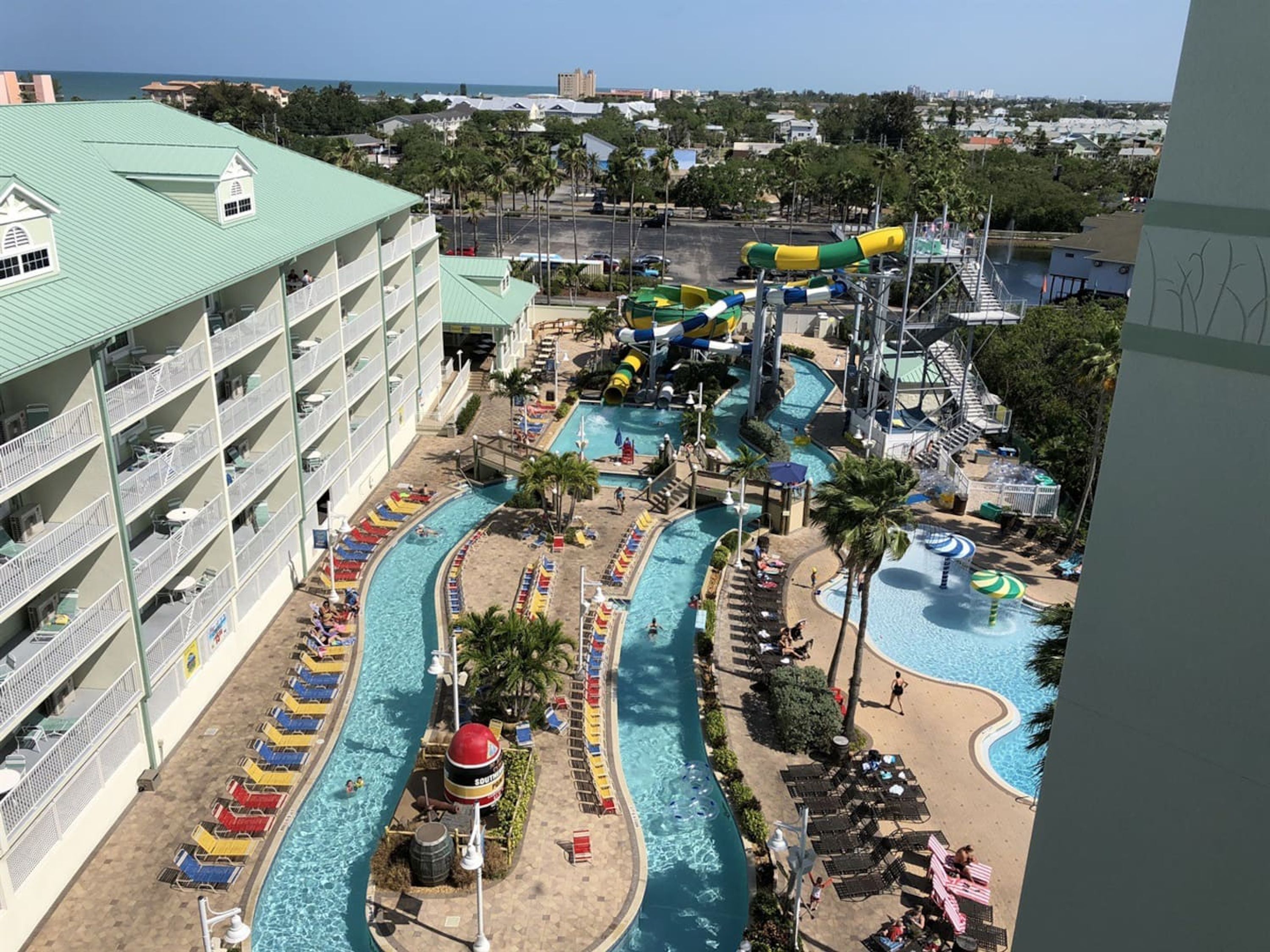A hotel with multiple swimming pools, a water park, and a view of the ocean.