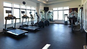 Ein Fitnessstudio mit Laufbändern, Crosstrainern und Kraftgeräten.