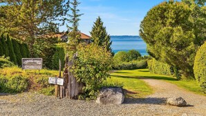 A gravel path leading to a wooden sign indicating a marina view departure. - Coastal Haven Seaside Serenity Retreat (Federal Way)