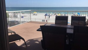 A balcony with a view of the beach, white railing, and a table with chairs. - The Old Man the Sea-seaview 101 (Madeira Beach)