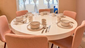 A round dining table set with plates, bowls, cups, and cutlery. - Breathless Backyard Amazing Pool (Largo)