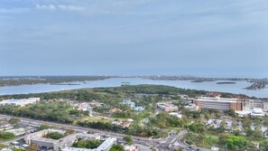 A coastal cityscape with a marina, green spaces, and modern buildings.