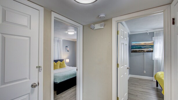 Un dormitorio con una cama, una mesita de noche y un televisor de pared.
