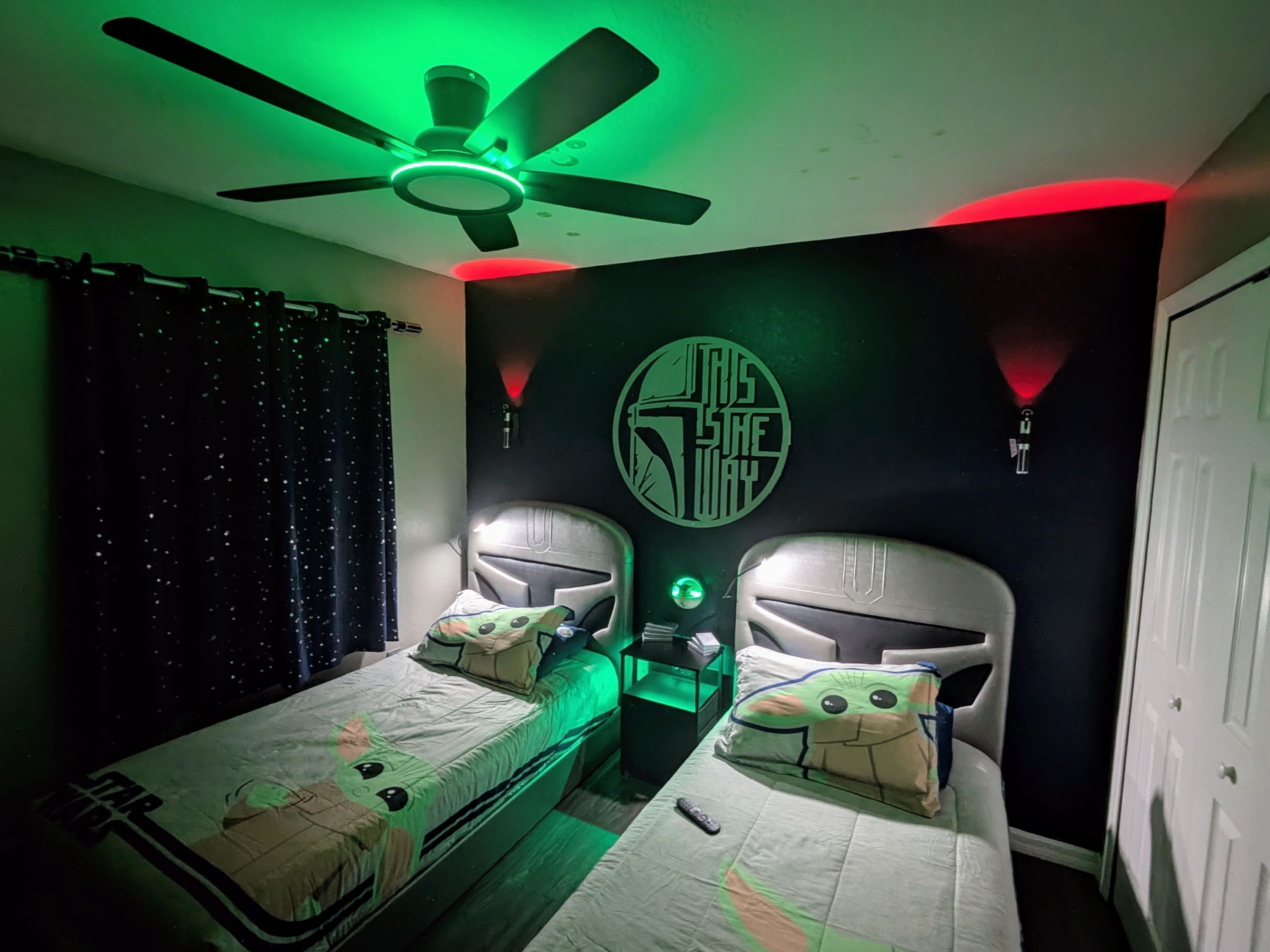 Quarto com duas camas, ventilador de teto e decoração temática de Star Wars.
