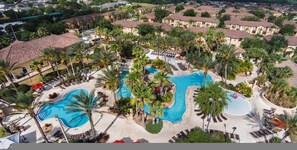 Ett semesterparadis med flera pooler, omgivet av palmer och avkopplande loungeområden.