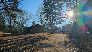 Une cabane offrant une vue dégagée sur la forêt environnante et un sentier menant à celle-ci.