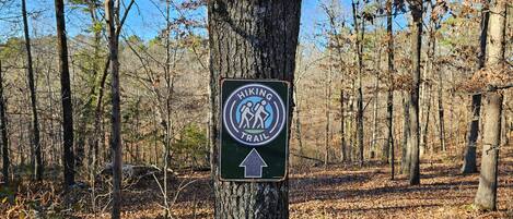A hiking trail sign in a forested area.