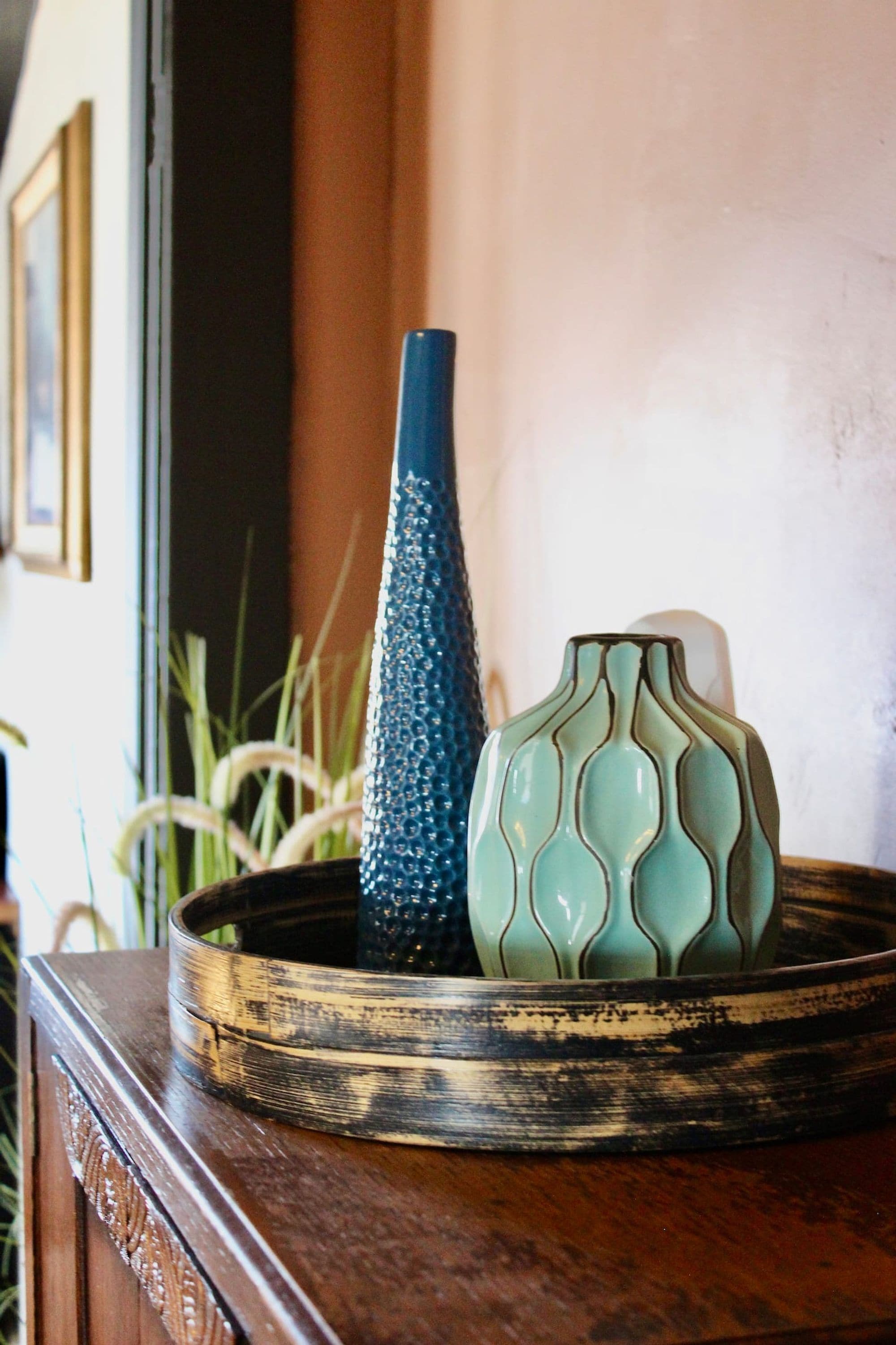 A tray with two vases on a wooden surface.