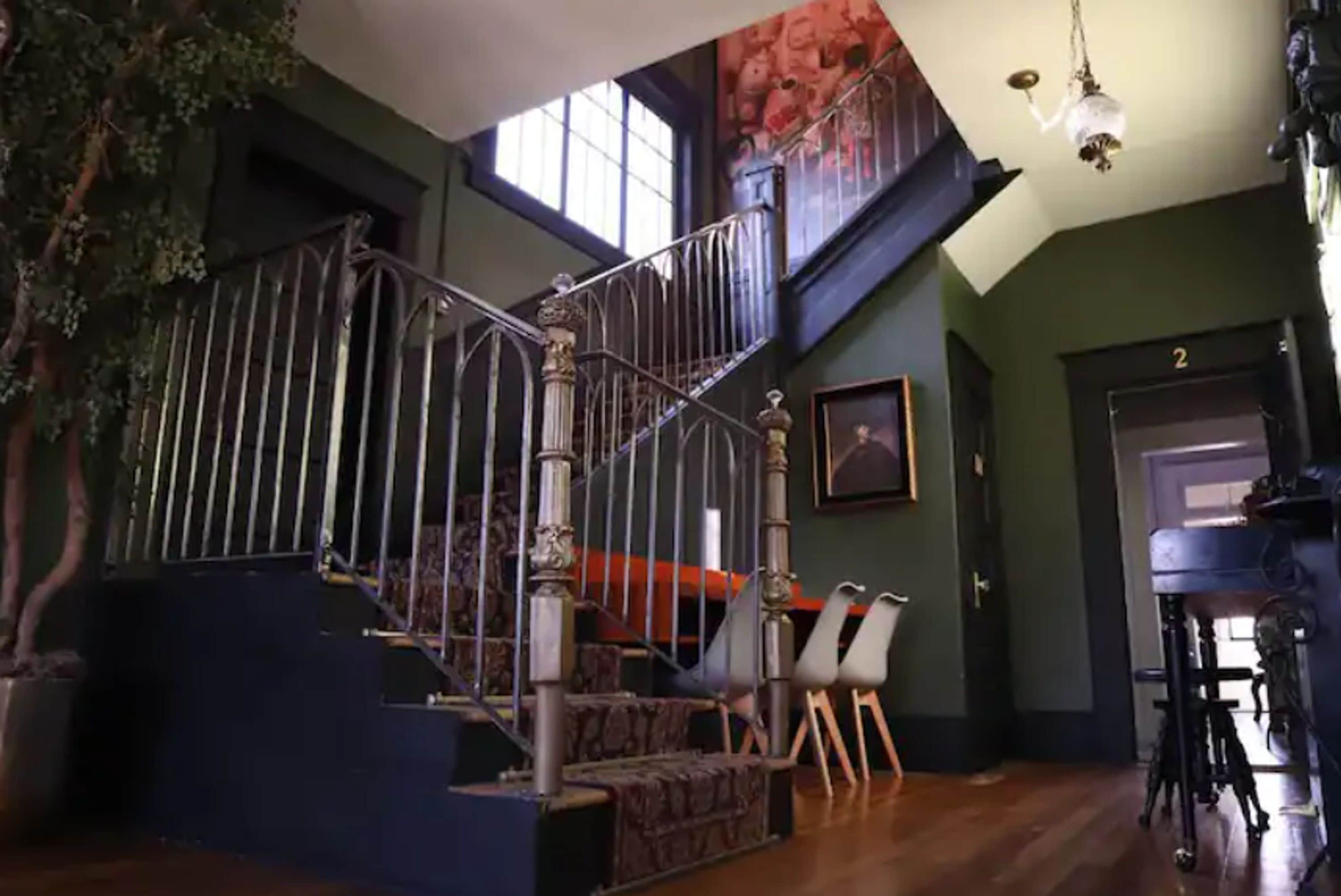 A staircase with a metal railing, wooden steps, and a view of the upper floor.