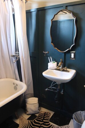 A bathroom with a white sink, a mirror, and a bathtub. - Casa Mina 3 Central Rio Grande Historic Dist (El Paso)