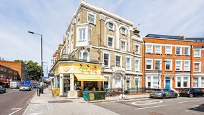 A street view with a coffee shop named "Crazy Coffee" on the corner, adjacent to a row of terraced houses. - Cute and Cosy Apartment in Kensington (London)