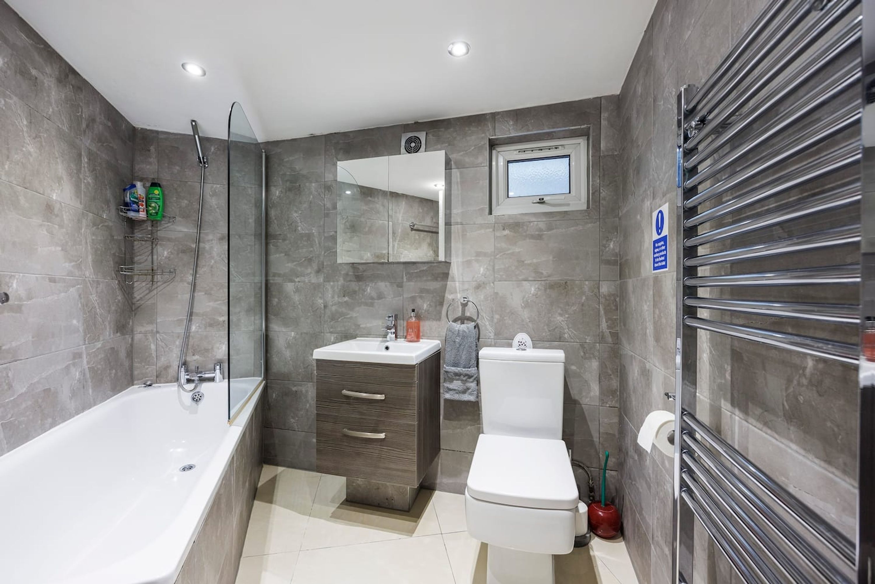 A modern bathroom with a bathtub, a sink, a toilet, and a shower.