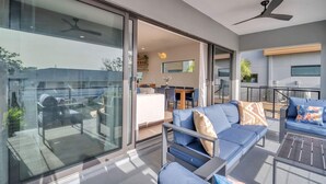 A modern living room with a sofa, coffee table, and a ceiling fan. - NEW 4 Bed 3 Bath Heated Salt Pool Walk2beach (Indian Rocks Beach)