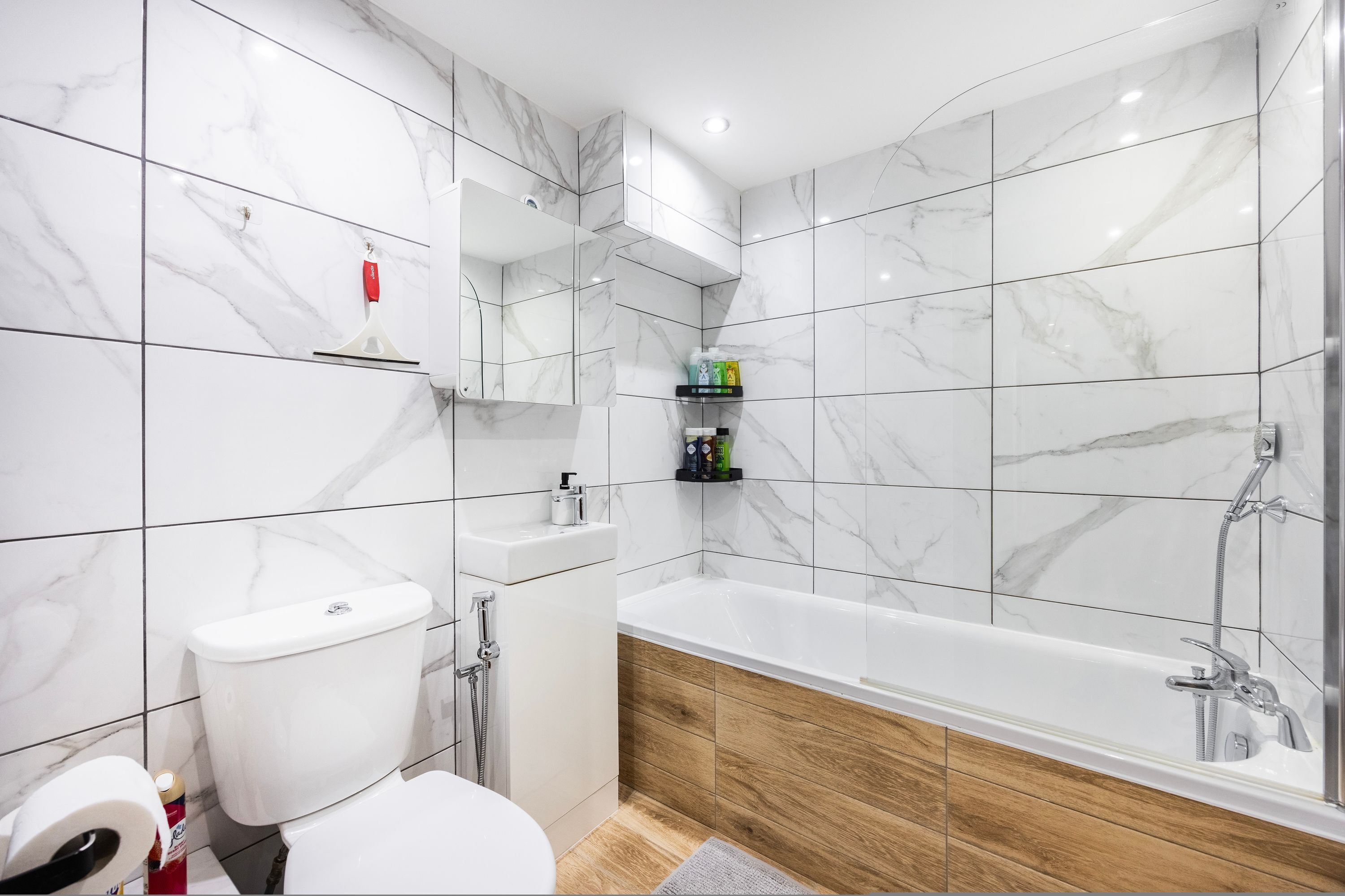 A modern bathroom with a toilet, sink, and bathtub.
