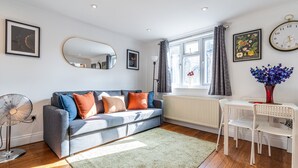 Ein modernes Wohnzimmer mit einem grauen Sofa, einem weißen Tisch und einem grünen Teppich.