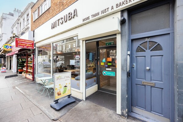 A storefront with a sign reading "MITSUBA" and a blue door with the number 92.