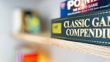 Um close-up de um jogo de tabuleiro intitulado 'POINTLESS' numa estante.