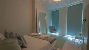 A modern hotel room with a large bed, a sitting area with a chair, and a large mirror. - Seaview Apt Turner Contemporary Margate By Adliv (Margate)