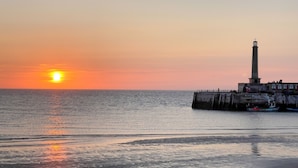 A coastal sunset with a lighthouse and pier. - Seaview Apt Turner Contemporary Margate By Adliv (Margate)
