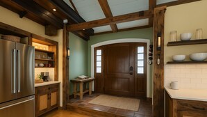 A kitchen with wooden beams, a stainless steel refrigerator, and a wooden door. - Magical Post and Beam Loft Downtown Newport (Newport)