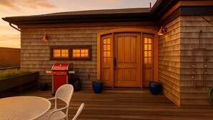 A wooden deck with a table and chairs, a barbecue grill, and a door with a window. - Magical Post and Beam Loft Downtown Newport (Newport)