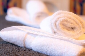 A neatly folded white towel and a rolled towel on a textured surface. - Cosy Margate Getaway Sleeps 5 By Adliv (Margate)