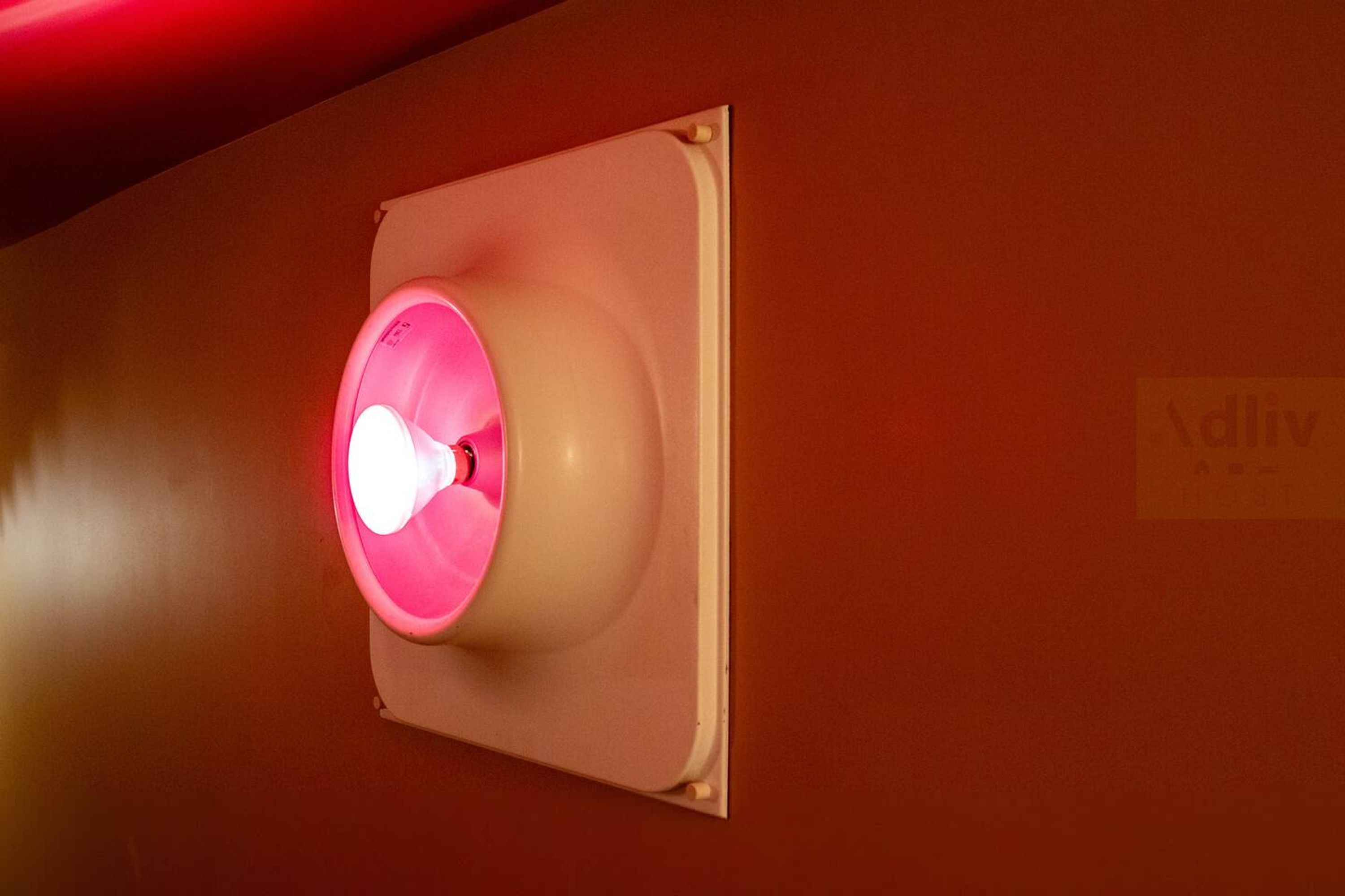 A wall-mounted emergency exit sign with a red light.