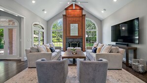 A spacious living room with two sofas, a coffee table, and a fireplace. - Private Riverbank 27-acre Estate 1 hr From Chicago (Kankakee)