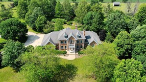 A large, two-story house with a prominent front porch and a driveway leading to the entrance. - Private Riverbank 27-acre Estate 1 hr From Chicago (Kankakee)