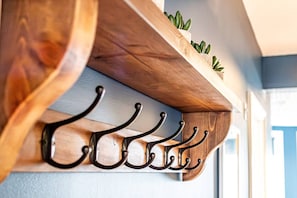 A wooden shelf with a plant and a row of metal hooks. - Stunning Sea View Georgian Retreat by Adliv (Margate)