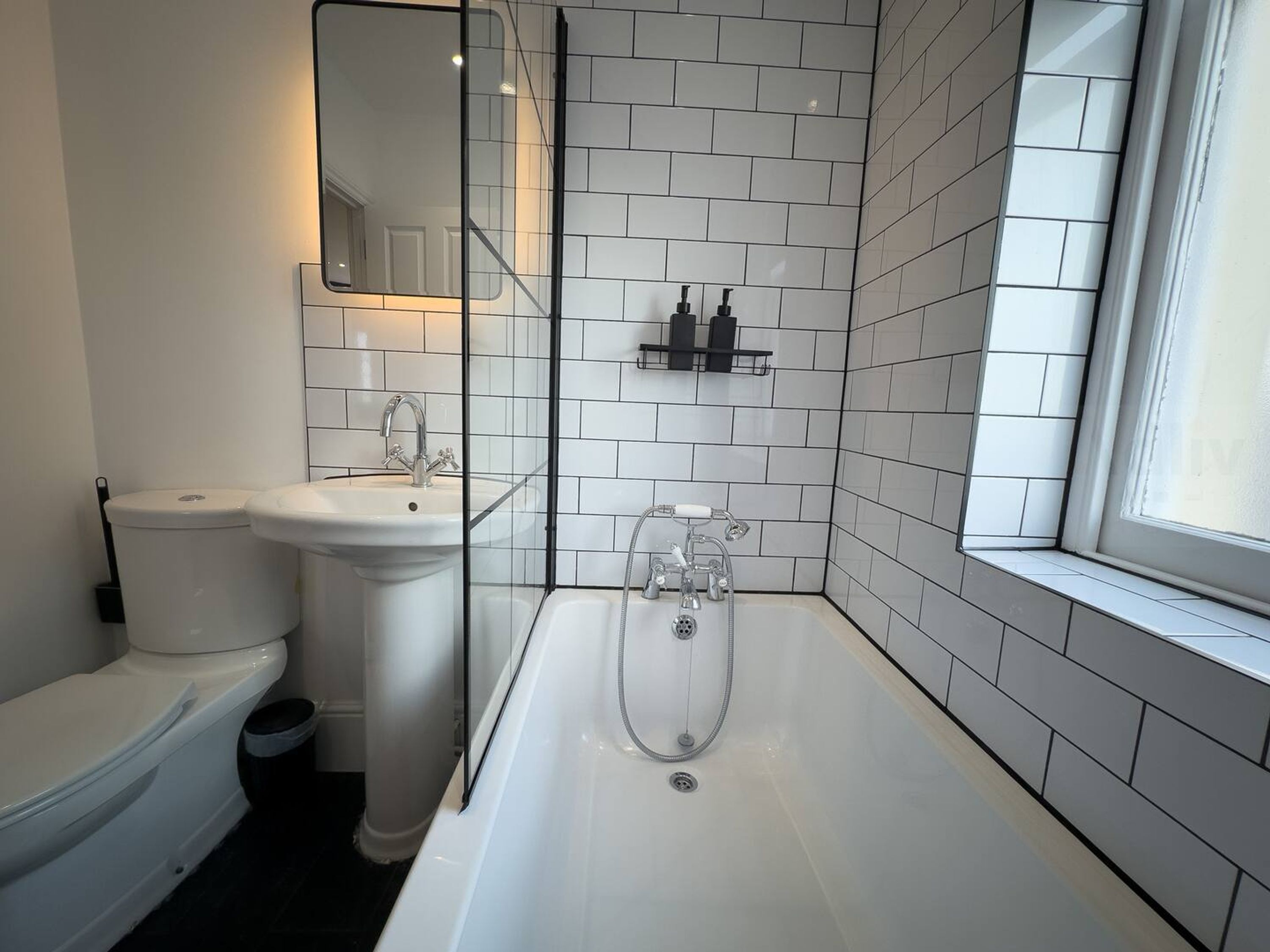 Une salle de bain moderne équipée de toilettes, d’un lavabo et d’une baignoire.
