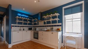 Una cocina moderna con armarios blancos, horno empotrado y ventana con vistas.