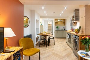 Una cucina moderna con zona pranzo, lavatrice e TV.