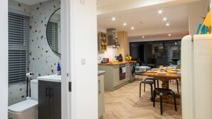 A modern kitchen with a central island, built-in appliances, and a dining area with a wooden table and chairs.