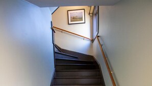 Una escalera con barandillas de madera y un cuadro en la pared.