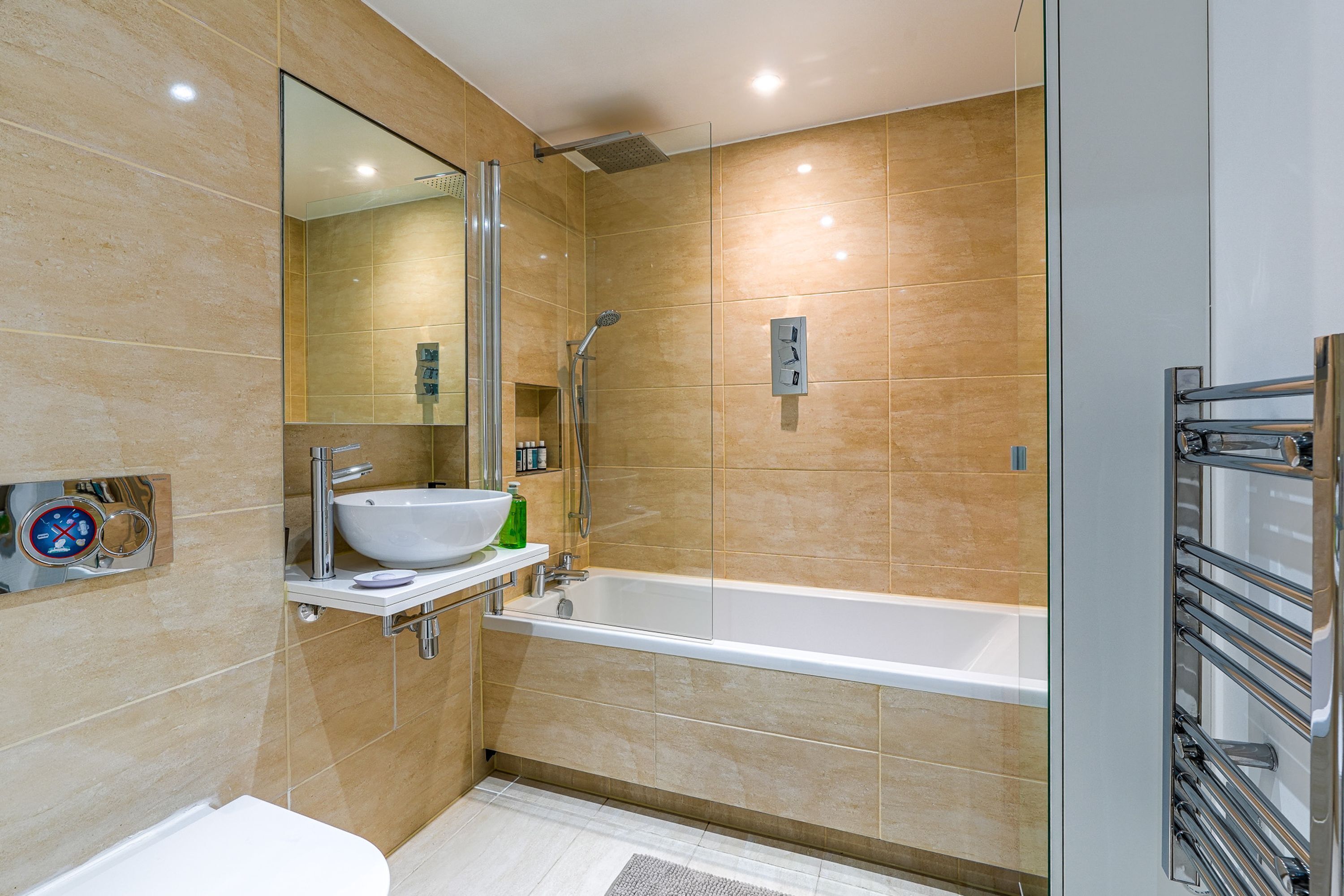 A modern bathroom with a large bathtub, a sink, and a glass shower enclosure.