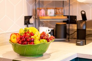 A green bowl filled with various fruits on a kitchen counter. - Old Town Trinity Apt No 4 By Adliv (Margate)