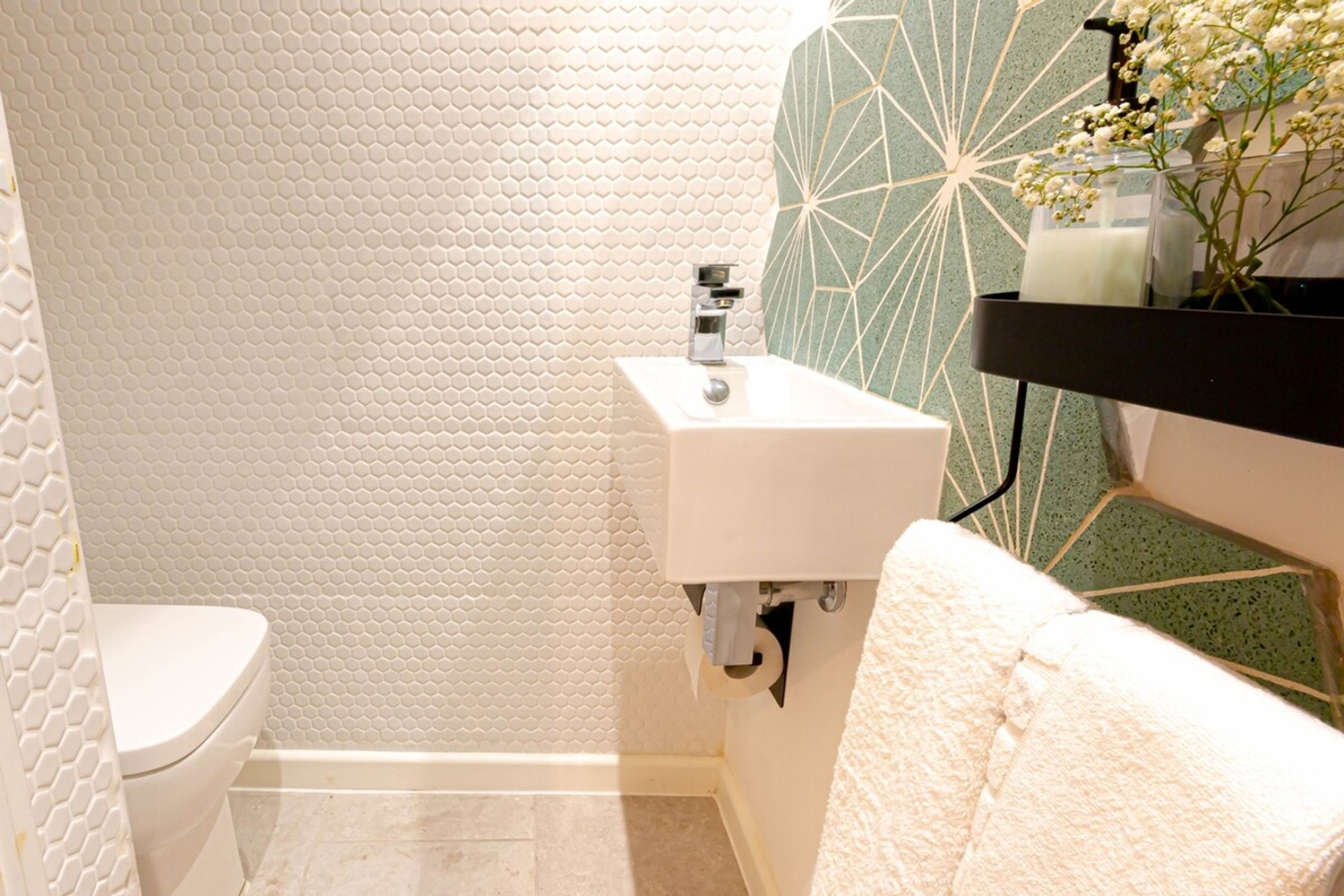 A bathroom with a toilet, sink, and a towel rack.
