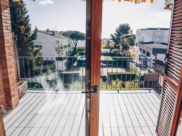 A balcony with a view of residential buildings and trees.