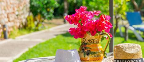 Et bord med en vase med blomster, en hat og en nøgle.