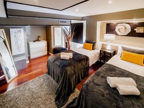 A modern hotel room with two beds, a desk, a chair, and artwork on the walls. - Victoria City Center 1 Downtown Luxury Duplex (Barcelona)