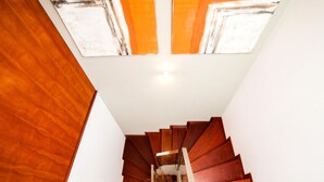 Una escalera en espiral de madera con techo de cristal y vista al cielo.