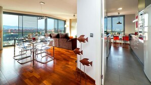 Un apartamento moderno con comedor, cocina y ventanas amplias que ofrecen vistas a la ciudad.