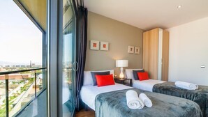 Una habitación de hotel con dos camas, un ventanal grande y vistas de la ciudad.