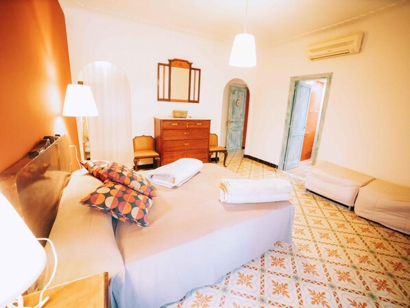 A hotel room with a bed, a dresser, a chair, and a desk.