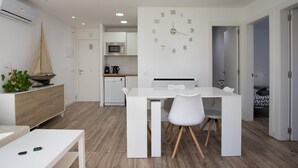A modern kitchen with white cabinetry, a microwave, and a coffee maker. - Apartament amb Piscina i Parquing Baixos amb Jard (Palafrugell)