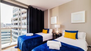 A hotel room with two beds, a large window, and a view of a building. - Victoria Diagonal Mar 2 Design Duplex Penthouse (Barcelona)