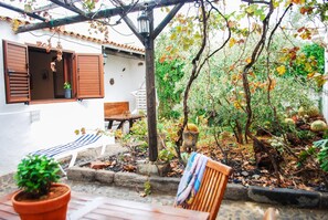 A patio with a wooden bench, a table, and a potted plant. - La Casita de Andres 1 (Aguimes)